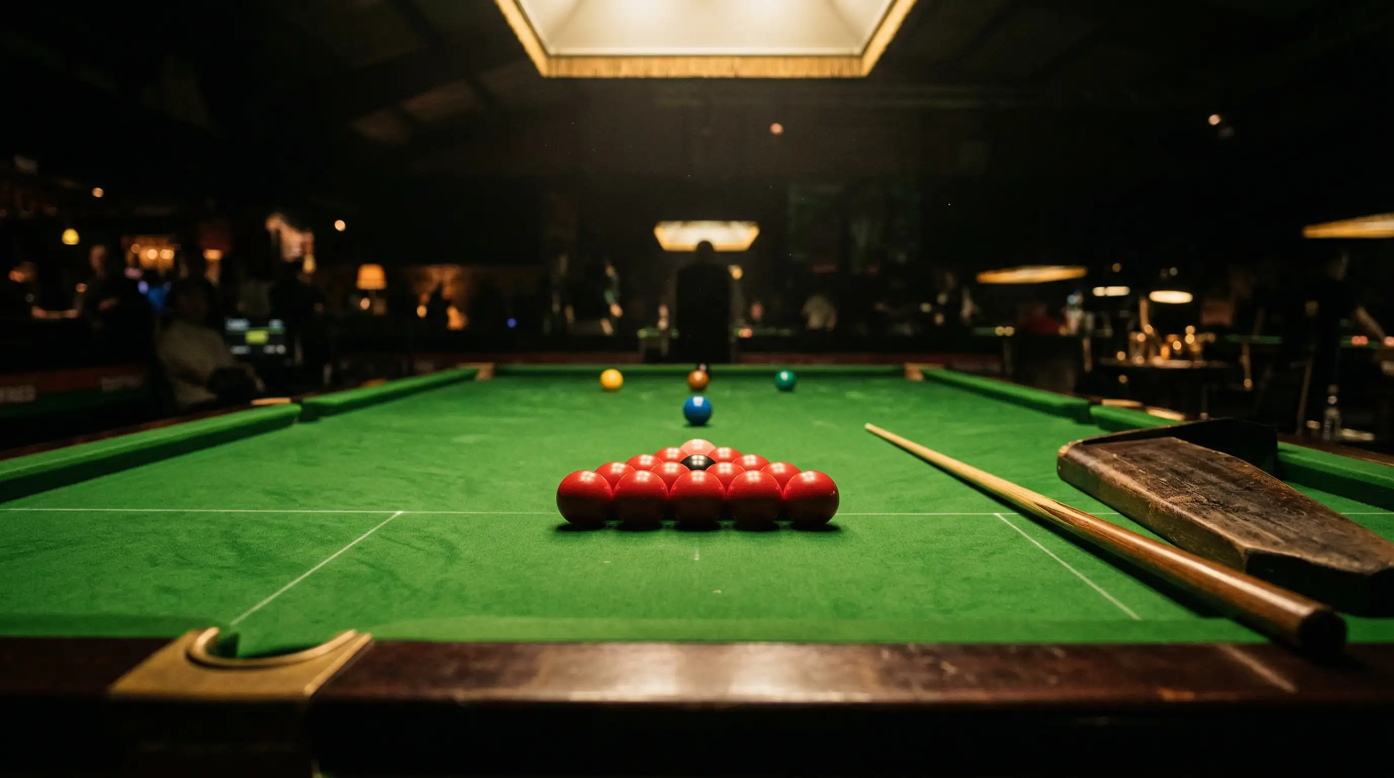 Profesjonalny stół snookerowy z zielonym suknem i rozstawionymi bilami, oświetlony charakterystycznym światłem areny